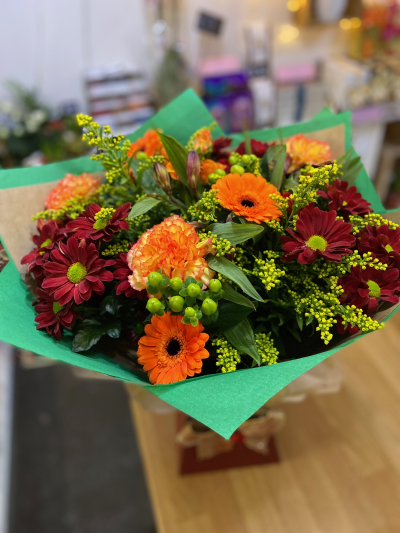 Winter Delight - A lovely mix of seasonal flowers and foliage in warming oranges and reds.  This bouquet is a perfect winter gift.