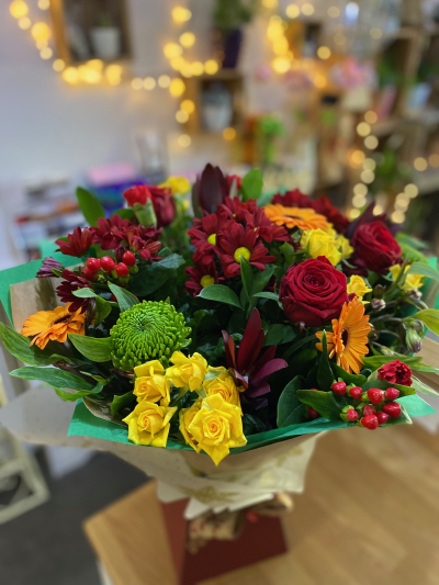 Winter Wonderland - A beautiful splash of winter colours in this mix of reds, yellows, oranges and greens.  A selection of chrysanthemums, carnations, berries, roses, germini and alstroemeria, a perfe